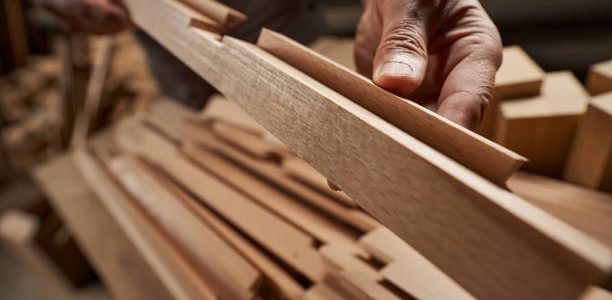 Professional joiner standing at workshop and manufacturing furniture for sale